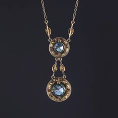 The radiant natural blue zircons in this necklace are as delightful as the crystal blue waters of the Caribbean and have the same capacity to entrance all those who gaze upon their sparkling blue brilliance. This elegant Victorian necklace (circa 1880) is extraordinary in every aspect. It features two round natural blue zircon stones of approximately 2.75 carats and 1.75 carats. Each heavenly blue zircon is surrounded by hand strung natural seed pearls and hand-set gold leaves which create a garland design around each stone. The paper clip chain is 18 inches long and the dangle is 1.8 inches. The spring clasp is marked 14k. This piece is in spectacular condition with only some minor tarnish to the reverse (consistent with age). Materials: blue zircon, zircon, gold, 14k gold, 14k, pearl. Blue Pendant Necklaces With Rose Cut Diamonds, Blue Rose Cut Diamond Pendant Necklace, Blue Rose Cut Diamond Pendant Jewelry, Blue Rose Cut Diamond Necklaces For Weddings, Formal Blue Necklace With Rose Cut Diamonds, Blue Rose Cut Diamond Necklace For Weddings, Blue Rose Cut Diamond Wedding Necklace, Heirloom Blue Necklaces For Weddings, Vintage Blue Jewelry With Diamond Cut