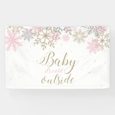 a white banner with pink and gold snowflakes on it that says baby is still outside