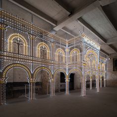 an indoor area with lights on the walls and arches