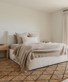 a bedroom with a large bed and white walls