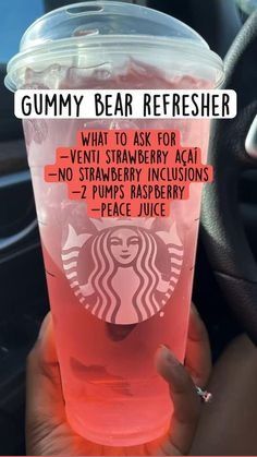 a person holding up a pink drink in their hand with the caption gummy bear refresher