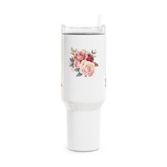 a white tumbler with pink roses on it and a straw sticking out of the cup