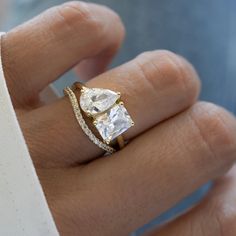 a woman's hand with a diamond ring on top of her finger and an engagement band