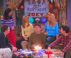 the cast of friends gathered around a birthday cake