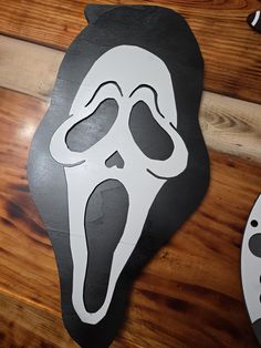 a wooden sign with a scream face on it