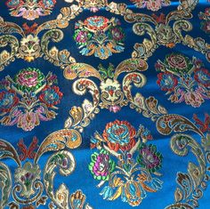 a blue background with gold, red and green designs on the fabric in different colors