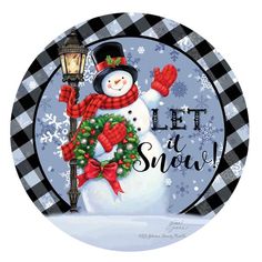 a snowman is holding a wreath and a lamp post with the words let it snow