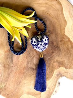 Dive into the boho-chic vibe with our captivating Boho Necklace, featuring a stunning Corazon Mexicano in blue and white made of the finest talavera mexicana. This unique piece captures the heart of Mexican artistry, giving you a slice of authentic talavera pottery to adorn your outfits. Hanging gracefully from a long, silky blue cord, the ceramic pendant is the centerpiece of this bohemian dream. It’s not just any pendant; it's a burst of Mexican culture wrapped up in a jewelry piece. And let’s Talavera Pottery, Blue Tassel, Beautiful Handbags, Ceramic Pendant, Mexican Culture, Dream It, Boho Necklace, Heart Charm, Long Necklace