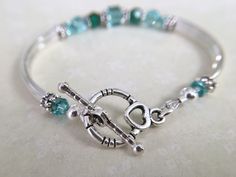 This bracelet has been uniquely created by combining emerald and light turquoise crystals together. Such a pretty combination! Perfect for your upcoming wedding to gift to your bridesmaids, mother of bride/groom, Jr bridesmaids, etc. OR, a great birthday, anniversary or just because gift. Choose from a toggle or lobster claw clasp from the dropdown menu at checkout. ~ 6mm and 4mm emerald and lt turquoise swarovski crystals ~ sterling silver bead caps ~ silver plated curbed tube bead bangles and Sterling Silver Bracelets For May Birthstone Anniversary, Adjustable Crystal Bracelet For Anniversary On Mother's Day, Sterling Silver Birthstone Bracelets For Wedding, Personalized Adjustable Crystal Bracelet For Anniversary, Adjustable Silver Crystal Bracelet With Birthstone, Adjustable Silver Birthstone Crystal Bracelet, Adjustable Sterling Silver Crystal Bracelet For Anniversary, Silver Beaded Bracelets With Birthstone For Wedding, Adjustable Birthstone Beaded Bracelets For Anniversary