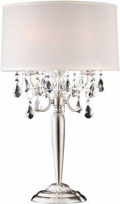 a table lamp with a white shade on it and crystal beads hanging from the base