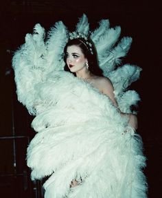 a woman in a white feather dress and headpiece