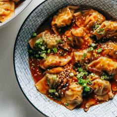 two bowls filled with dumplings covered in sauce