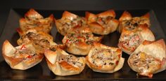 a tray filled with mini pizzas sitting on top of a stove