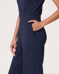 Experience unmatched comfort and style with our flared tank jumpsuit. Designed to transition you from office wear to a night out. With added elastic at waistband for a flattering fit, this piece ensures a tailored look when sized down. The keyhole back, secured with an elastic band and button, adds an elegant touch. Featuring functional zipper pockets and a minimal embroidered logo at the back, this jumpsuit is a versatile must have for any wardrobe. Made from our luxurious scuba fabric, it is h Chic Fitted Jumpsuits And Rompers With Elastic Waistband, Chic Fitted Jumpsuit With Elastic Waistband, Elegant Strapless Jumpsuit For Loungewear, Elastane Jumpsuits And Rompers, Fitted Wide Leg Jumpsuits For Loungewear, Fitted Jumpsuits And Rompers With Elastic Waistband For Work, Tank Jumpsuit, Scuba Fabric, Office Wear