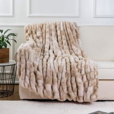 a white couch with a fur blanket on it