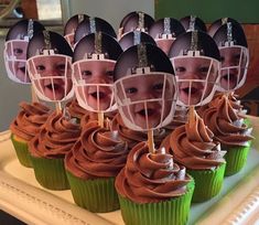 cupcakes with football helmets on them sitting on a plate