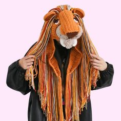 a person wearing a knitted lion mask with long dreadlocks on their head