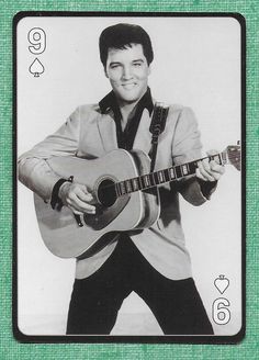 a black and white photo of a man holding a guitar in front of a playing card