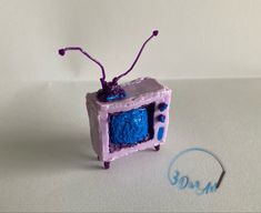 a blue and purple object sitting on top of a white table next to a marker