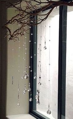 a bathroom with a tree branch hanging over the bathtub, and glass beads on the shower curtain