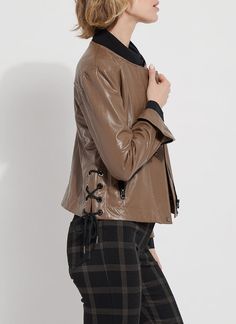 Made from 4-way stretch Textured Vegan Leather, the Kellie Bomber Moto Jacket features a cropped, slim fit, zip front, contrast-color ribbed jersey neck, back yoke, side pockets and gunmetal zip sleeves for easy cuffing. Combining bomber and moto jacket styling, the Kellie is an unlined jacket with a mesh yoke inside and a unique, side lace-up detail with metal eyelet and side ties. Layer the Kellie Bomber Moto over our Connie Slim Button Down and Patterned Baby Bootcut pants. Vegan Leather- 100 Fitted Leather Jacket With Zip Cuffs For Spring, Fitted Biker Jacket With Zip Cuffs For Spring, Versatile Fitted Brown Outerwear, Fitted Outerwear With Side Zipper For Fall, Fitted Fall Outerwear With Side Zipper, Sleek Stretch Outerwear For Fall, Chic Brown Stretch Outerwear, Chic Stretch Brown Outerwear, Fitted Cropped Jacket With Zip Fly For Fall