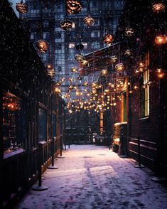 an alley way with lots of lights hanging from the ceiling and snow on the ground