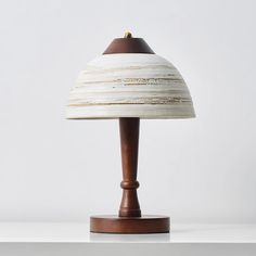 a wooden table lamp sitting on top of a white shelf