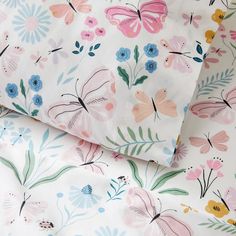 two sheets with colorful flowers on them and one has a butterfly print in the middle