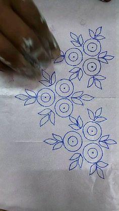 someone is drawing flowers on a piece of paper