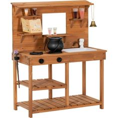 a wooden desk with a pot on top of it and shelves above the table that hold items