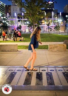 a woman is walking in the city at night