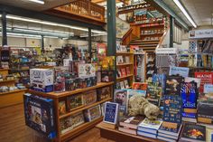 a bookstore filled with lots of books on top of wooden shelves next to a stair case