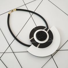 "A beautifull combination of black and white lines with black swarovski crystals in the center. A unique and sophisticated necklace that will upgrade any elegant outfit! Share with the world your exquisite taste! Lightweight necklace. * * * * * * * * * * * Materials: 0.24\"/6m\" thick black silicon cord 0.12\"/3m\"m thick plexiglass Swarovsky crystals resin acrylic colors Bib: height: 4.13\"/10.5c\"m width: 5.12\"/13c\"m max. thickness in circle center: 0.9\"/2.3c\"m Check out shop's Clip On Ear Elegant White Necklace, Resin Acrylic, Crystal Resin, Black And White Lines, Gold Statement Necklace, Bib Necklaces, Geometric Necklace, Black Necklace, Bib Necklace