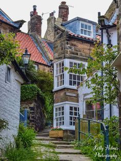 an alleyway between two buildings with stone steps leading up to the second floor windows