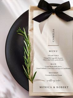 a black plate with a menu on it and a napkin tied to the side that has a bow