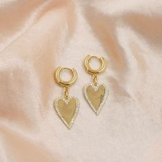 These sweet heart huggies pack some major style and shine. We love the thick huggie hoop and sparkly gold finish. DETAILS Charm hangs 1 inch long CZ accents Shiny gold finish 14kt gold plated brass Heart Huggies, Sweet Heart, Mini Heart, Gold Stud, Heart Studs, Dainty Jewelry, Huggies Earrings, Gold Studs, 14kt Gold