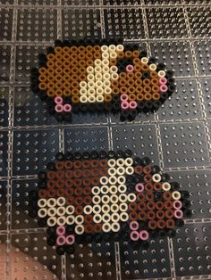 two pieces of bead art sitting on top of a table