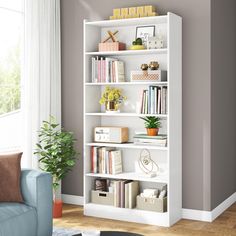 a living room with a blue couch and white bookshelf