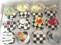 a box filled with black and white cakes covered in icing next to a clock