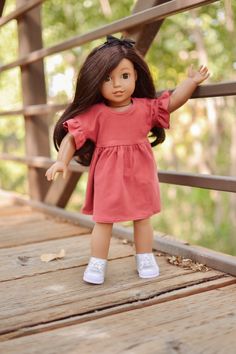 a doll is standing on a wooden bridge