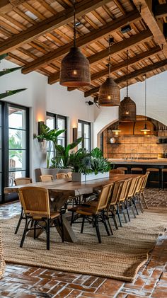 a dining room table and chairs in front of an open kitchen area with wooden beams