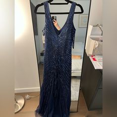 a woman taking a selfie in front of a mirror wearing a blue dress with sequins