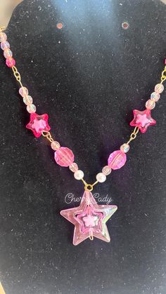 A handmade charm necklace that makes a perfect star-powered statement piece! The necklace is perfect for any concert, outing, or everyday wear! Necklace is 11 inches length wise! Party Star Charm Necklaces, Star Charm Necklace For Festivals, Handmade Star Necklaces For Party, Trendy Handmade Star-shaped Necklaces, Trendy Handmade Star-shaped Necklace, Handmade Trendy Star Necklaces, Trendy Pink Necklace With Star Charm, Trendy Handmade Star Necklaces, Pink Handmade Star Necklace