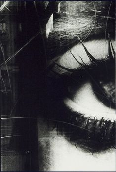 a black and white photo of an eye with long eyelashes, looking down at the viewer