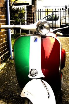 a motor scooter parked in front of a brick wall