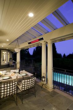 an outdoor dining area is lit up at night with lights on the table and chairs