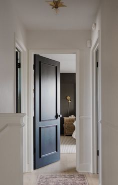 an open door leading to a hallway with a rug on the floor