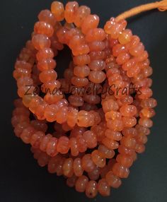 the beads are orange and have small holes in them, as well as an orange cord