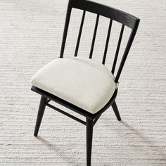 a black chair with a white cushion on top of it