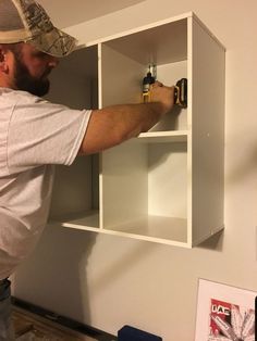 a man working on a shelf in a room